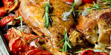 Морський окунь з помідорами та часником